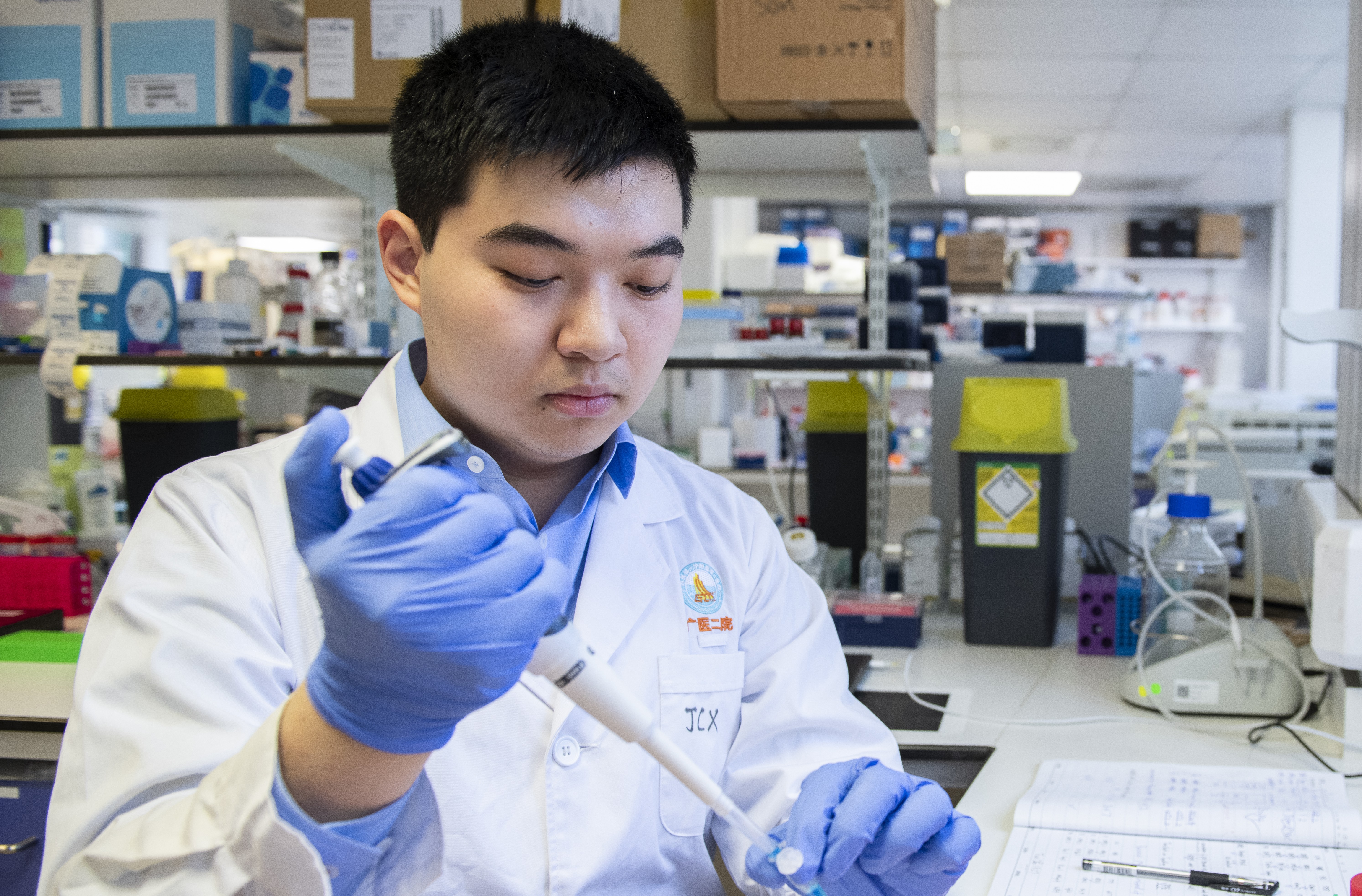 Professor Chu in the research lab working with a pipette