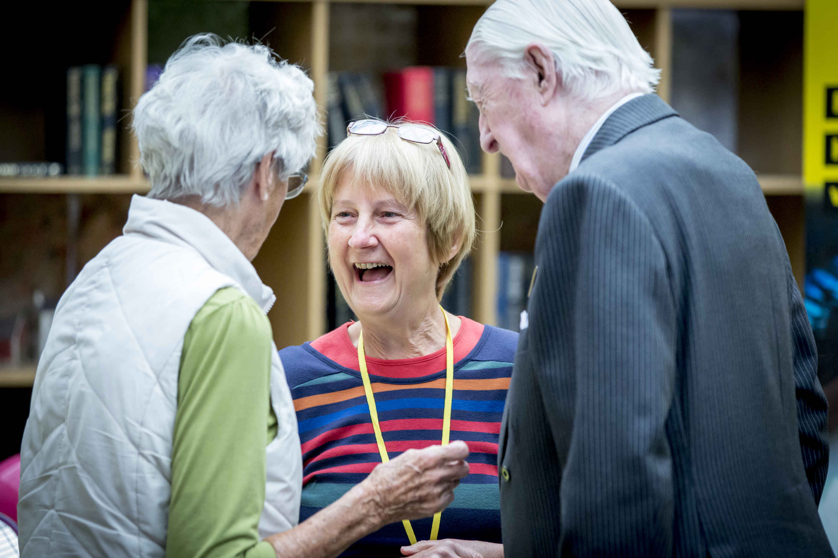 Three supporters chatting and smiling