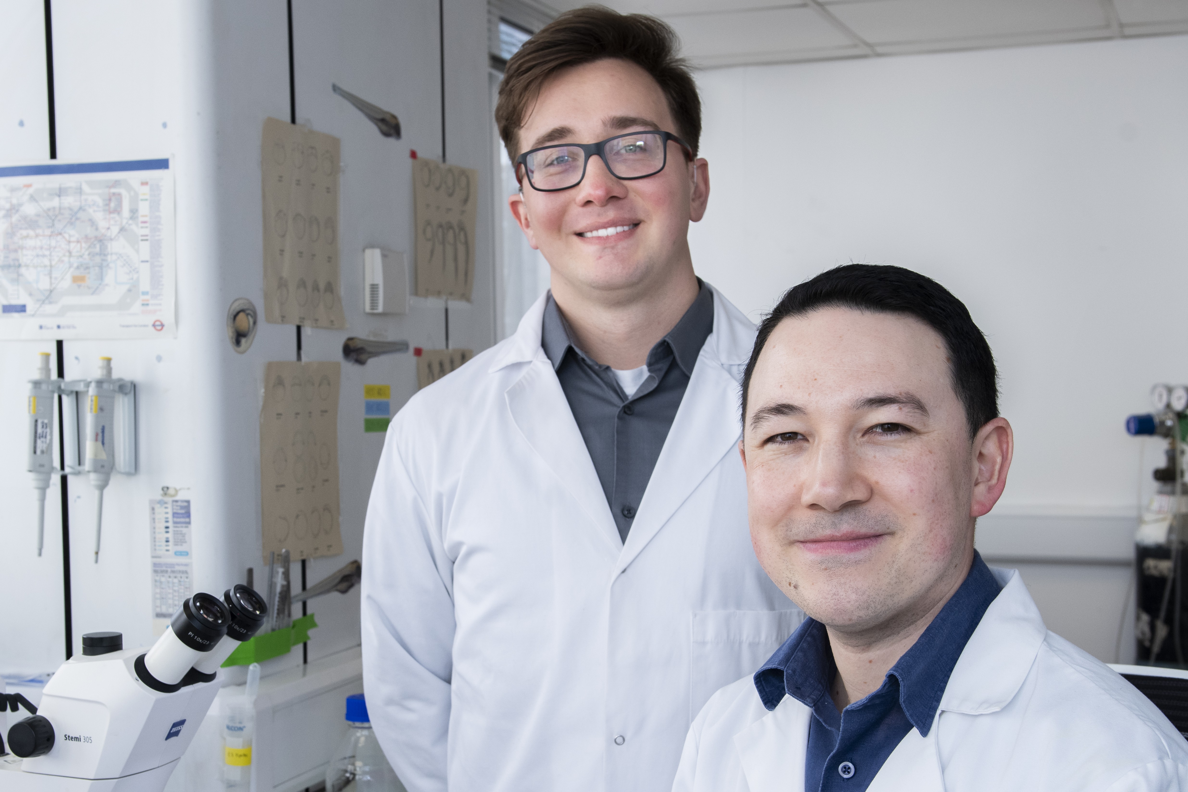Professor Chu and PhD student Kuba in the research lab smiling to camera