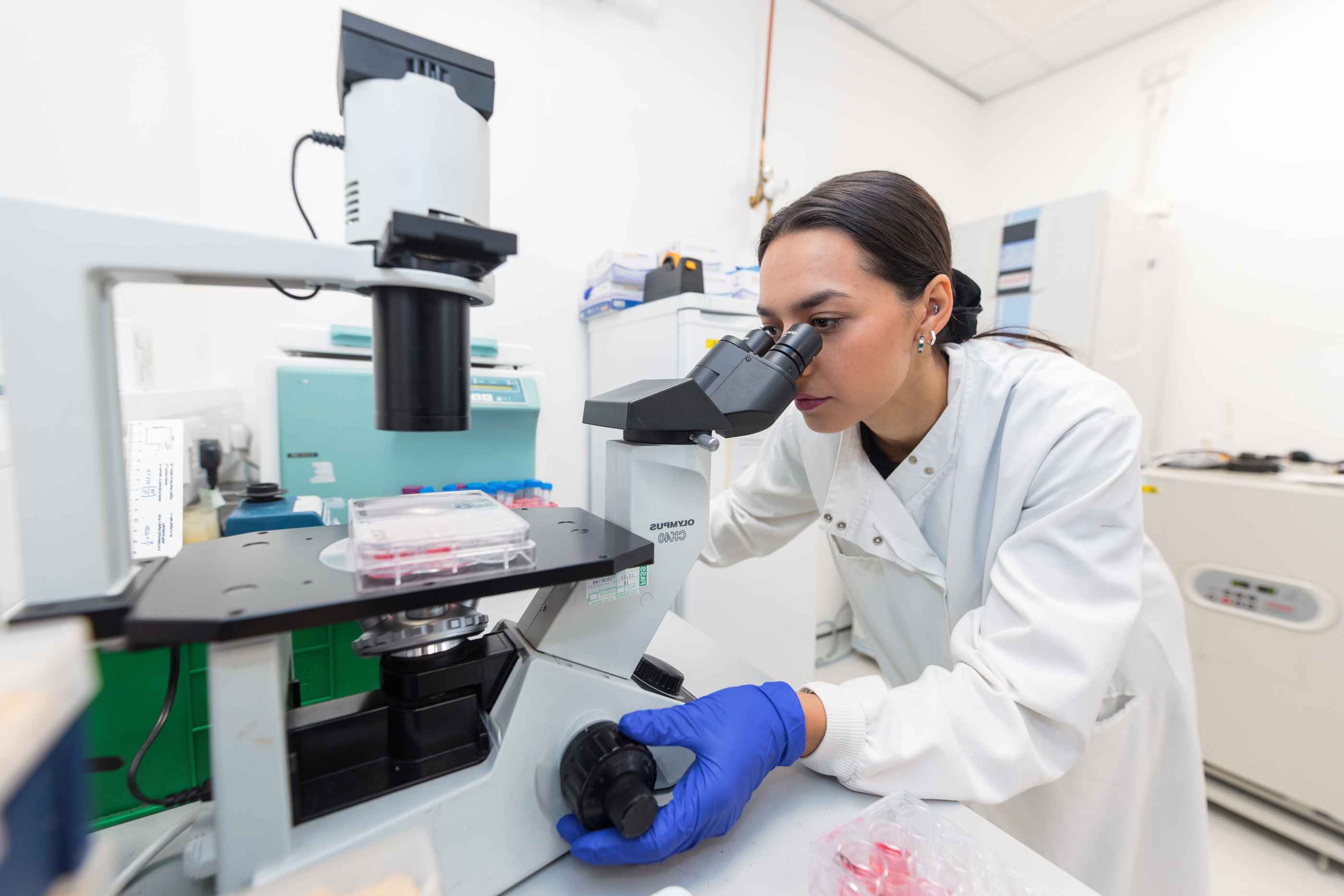 Phd Anneliza In Lab Looking Through Microscope For Homepage