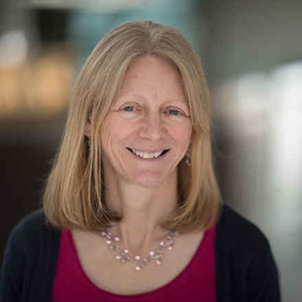 Professor Lynne Cox with blonde shoulder length hair smiling to camera 