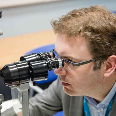 Pearse Keane looking into a microscope