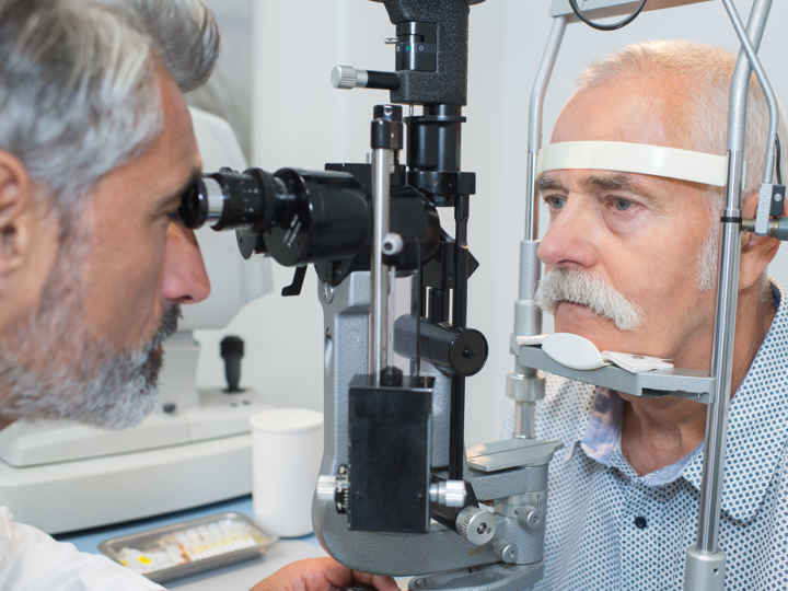 Man having eye test, leaning into eye examination machine.