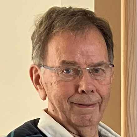 A headshot of Brian, an elderly gentleman in his 70s/80s looking to camera and smiling