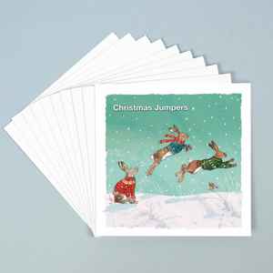 A stack of 10 greeting cards with three jumping hares in Christmas jumpers in the snow