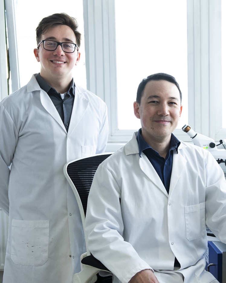 Dr Chu and Kuba in their labcoats smiling to camera