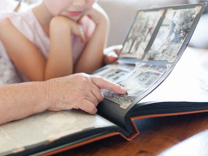 grandmother-granddaughter-looking-through-photo-album.jpeg