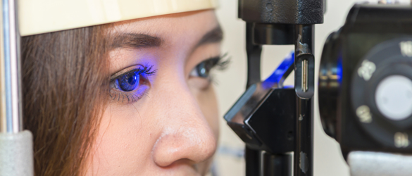 Woman having eye test with blue light.