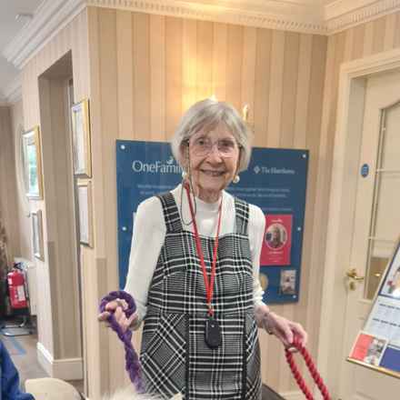 Rita, a white woman in her 80s with short grey hair smiling to camera