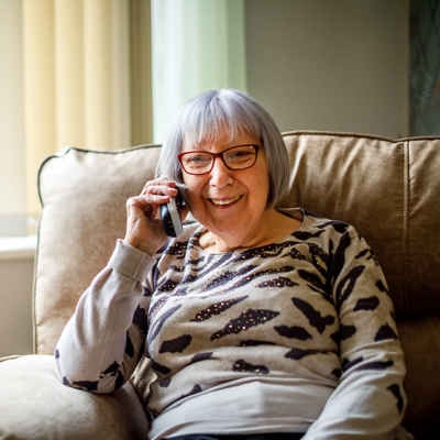 Volunteer, Audrey Drage smiling on the phone