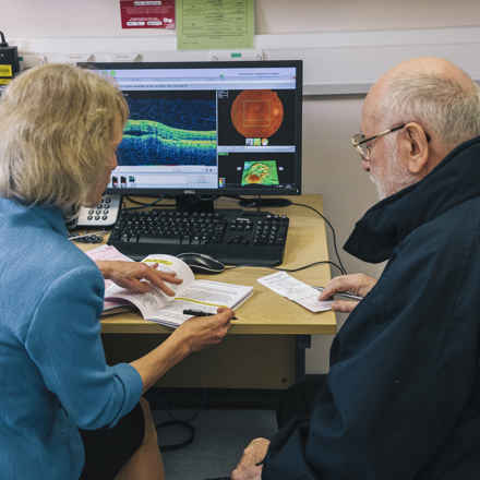 Female consultant, discussing results with male patient with computer images of results.