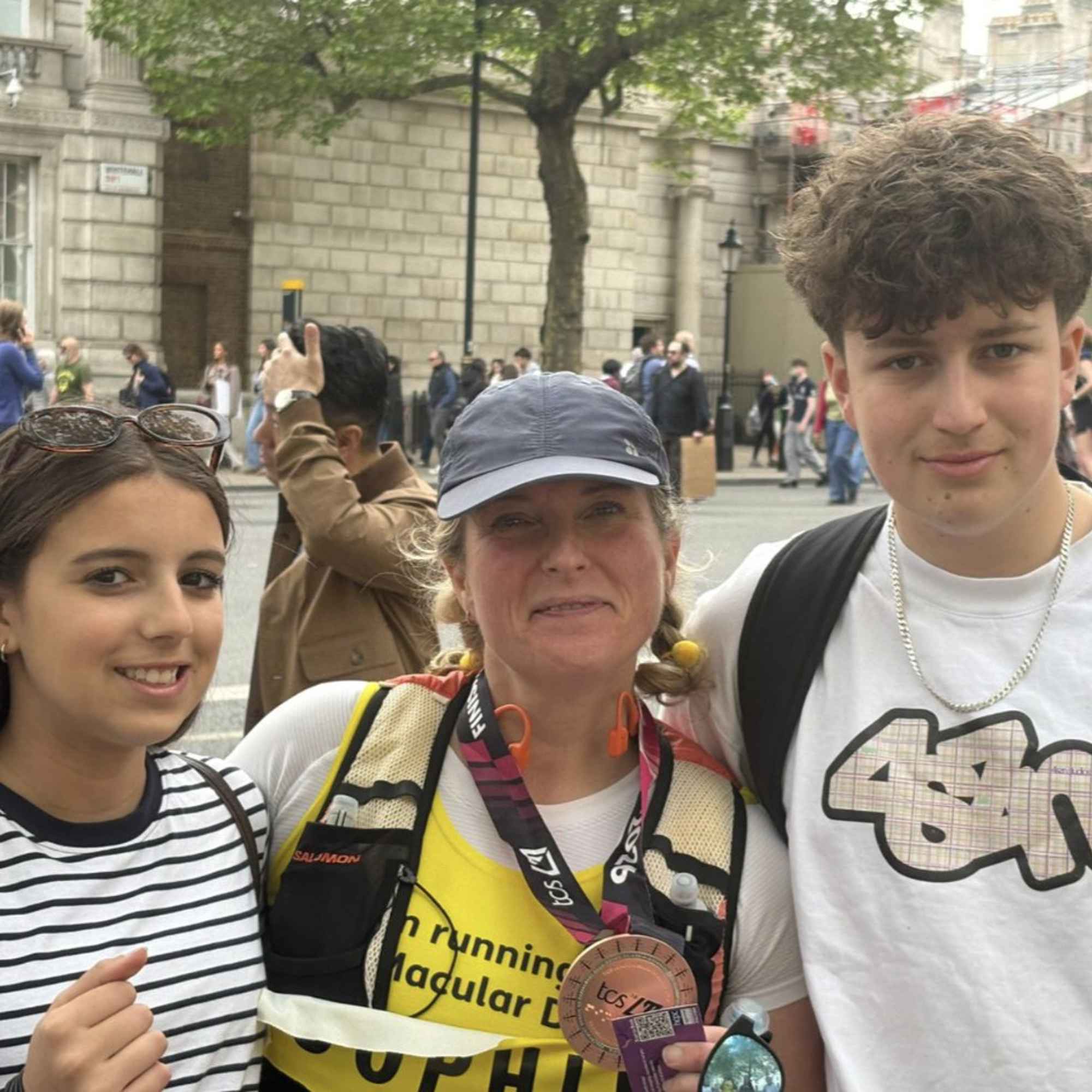 Sophie, middle, next to her daughter (left) and son (right) holding her London Marathon medal