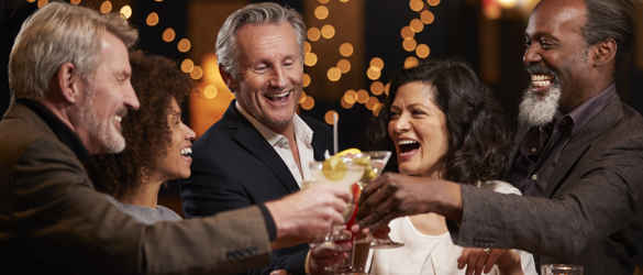 Group with drinks celebrating in bar