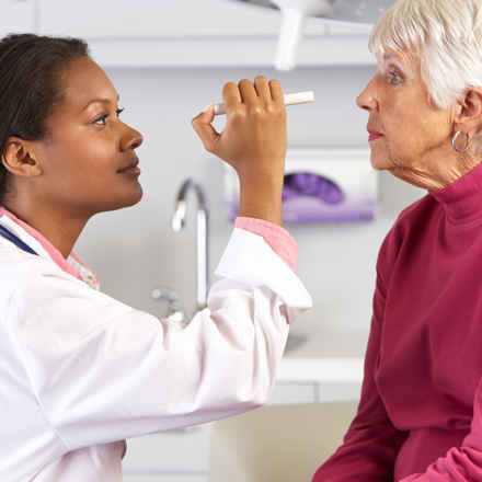 Nurse Looks Into Eyes Of Elderly Patient