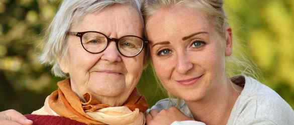 Granddaughter and grandmother hugging and smiling