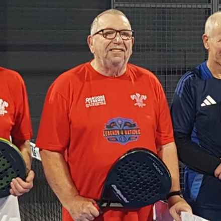 Paul in his red Wales jersey, holding his padel racket