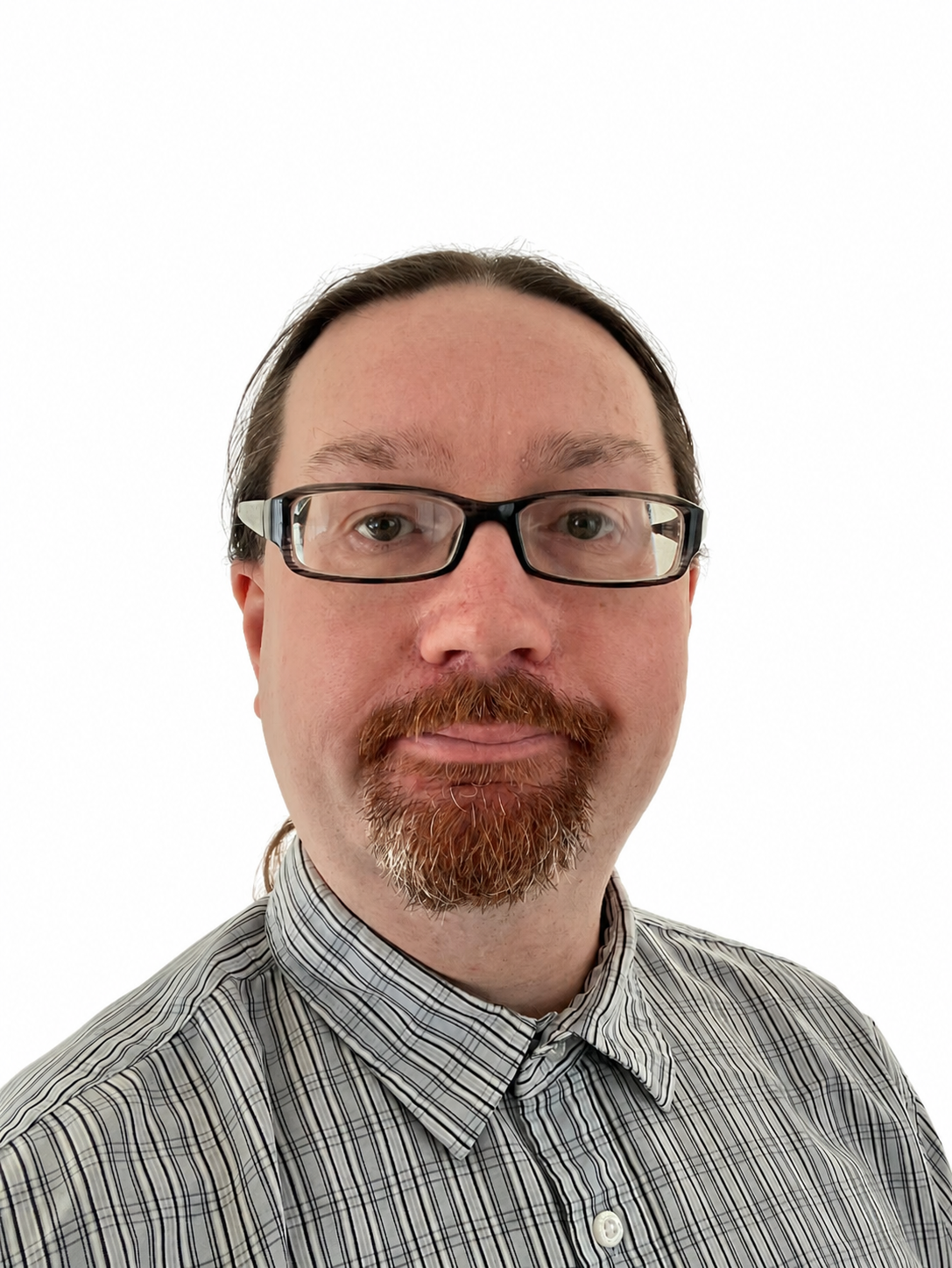 Dr Ashley Wood a white male, with long hair tied back and a beard, wearing thick rimmed black glasses and smiling to camera.