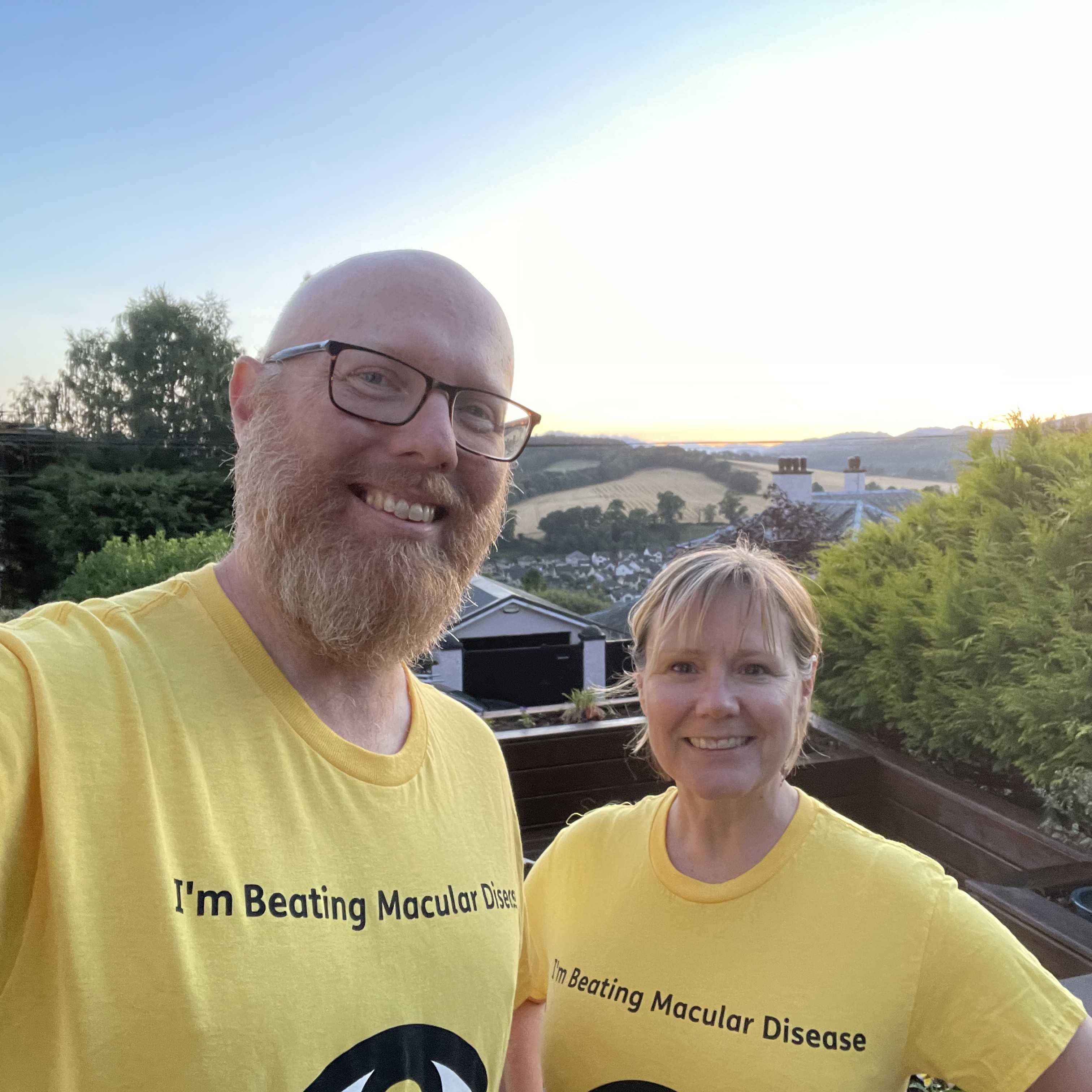 Husband and wife Chris and Lisa wearing their yellow Macular Society fundraising t-shirts