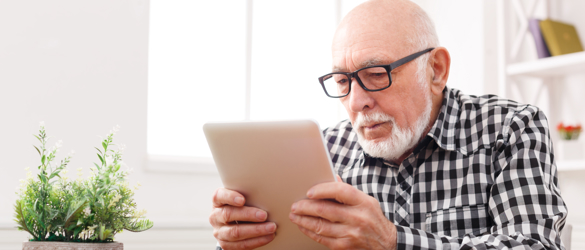 Man with glasses, looking at tablet