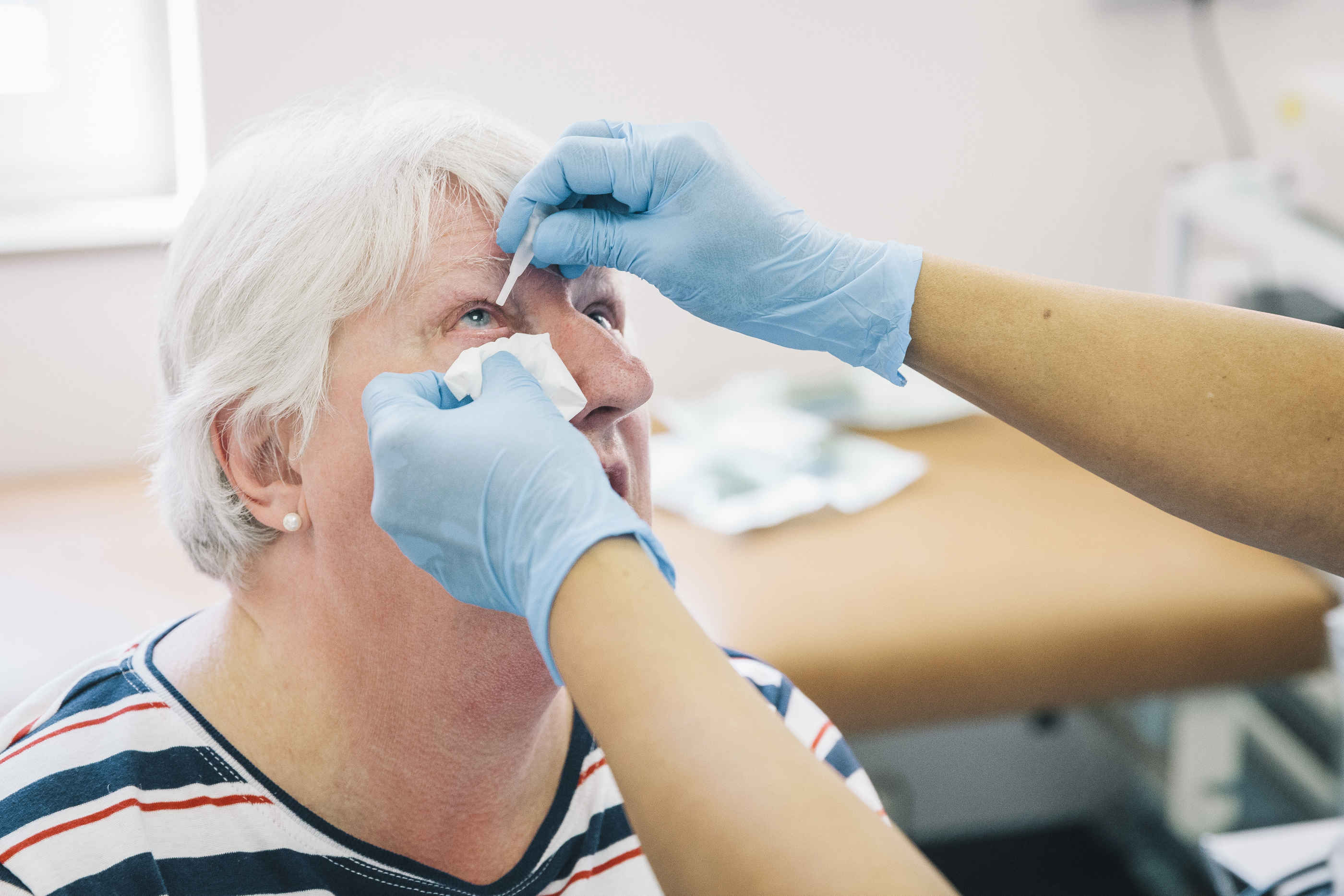 eye-drops-senior-woman-blue-gloves.jpg