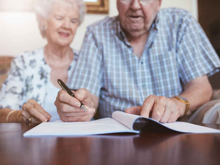 Elderly couple signing documents